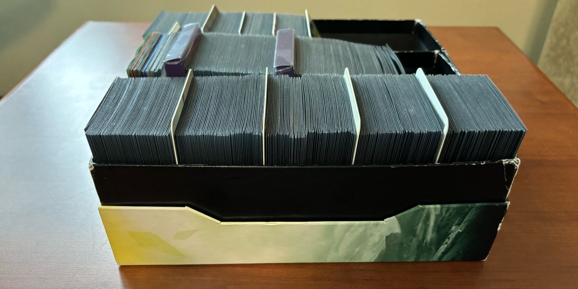 Коробка для хранения, содержащая 450 карт Magic с двойными рукавами, включая базовые земли и жетоны.